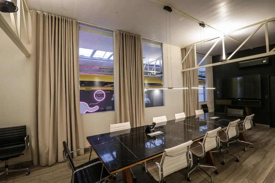 Sala de directorio con mesa de mármol negro y sillas blancas en Host Orfeo